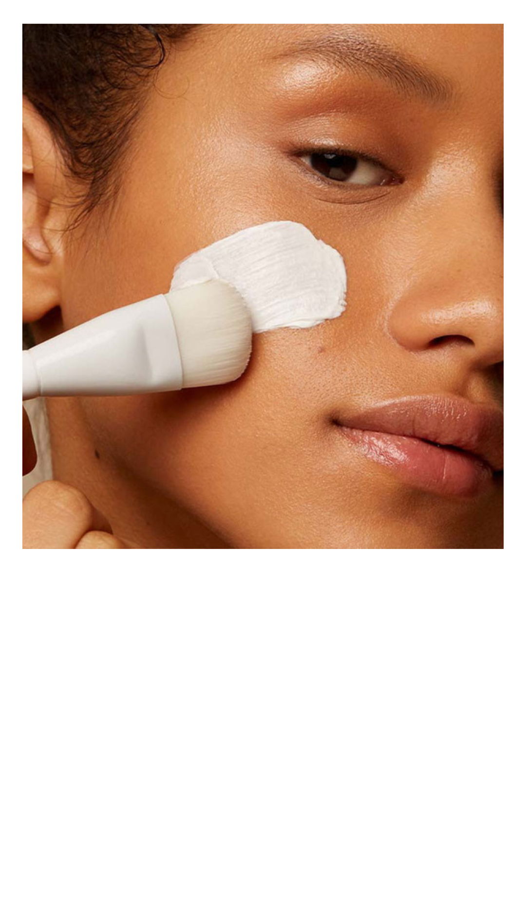 A person applying a facial treatment with a brush.