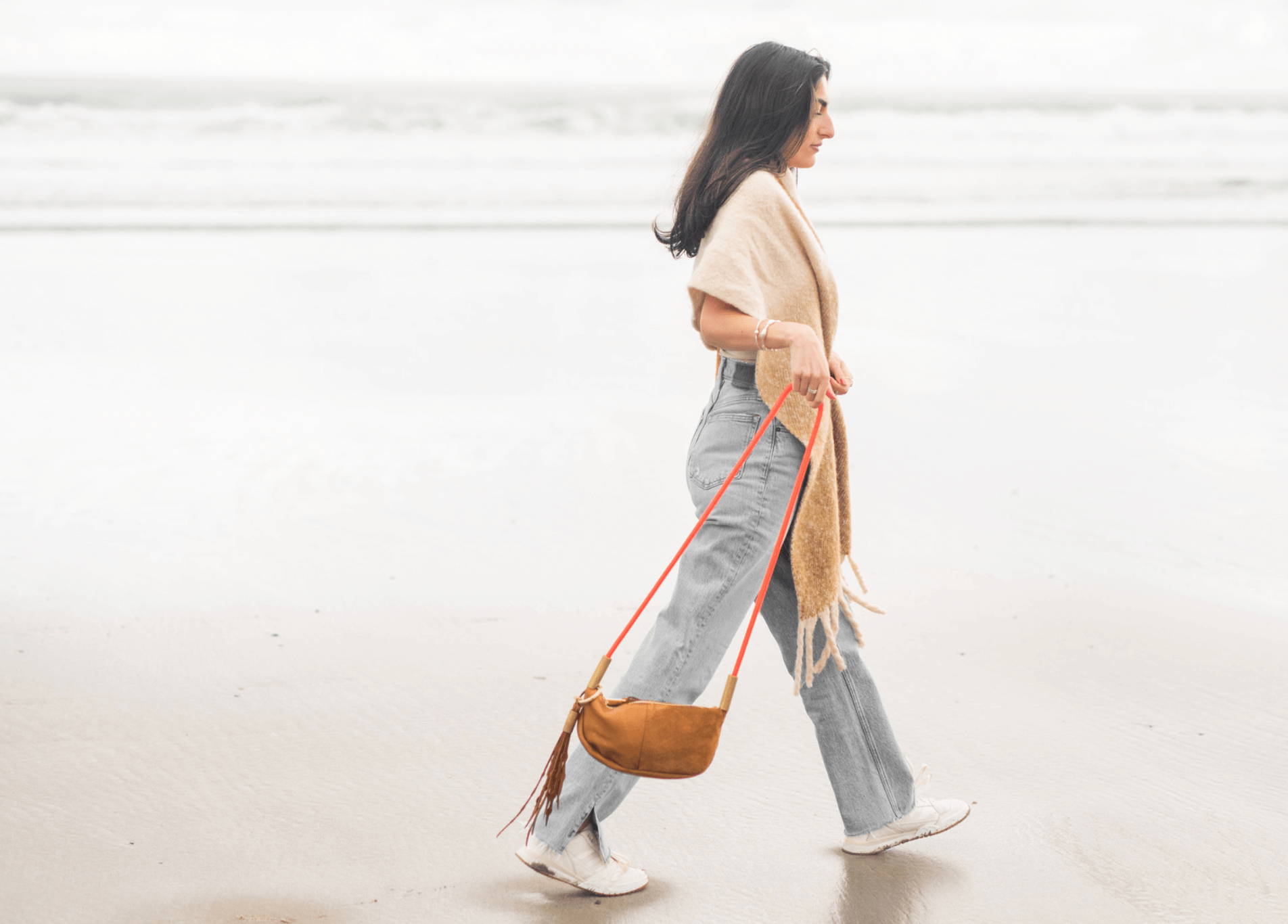 woman walking on the beach with a zip crossbody