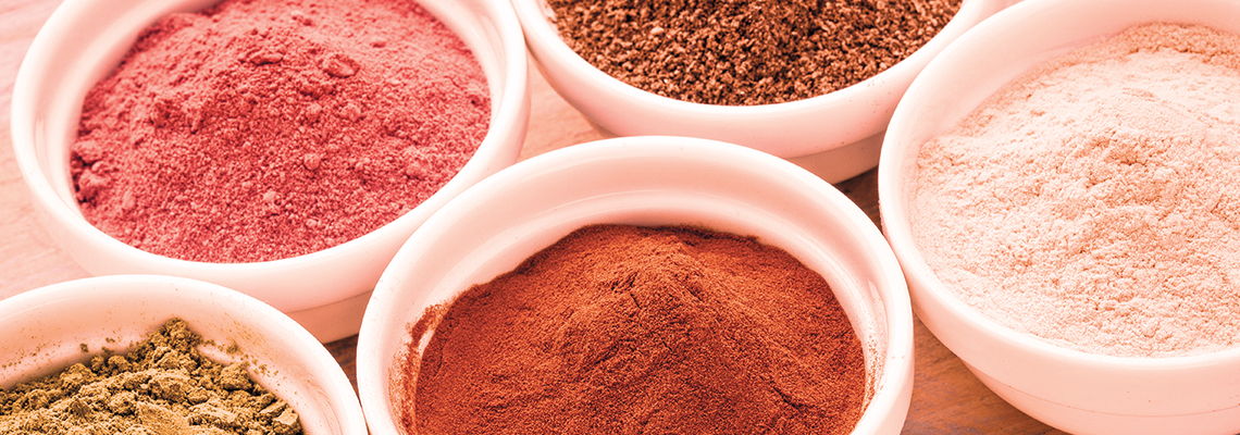 Bowls of various colorful spices and powders arranged aesthetically.