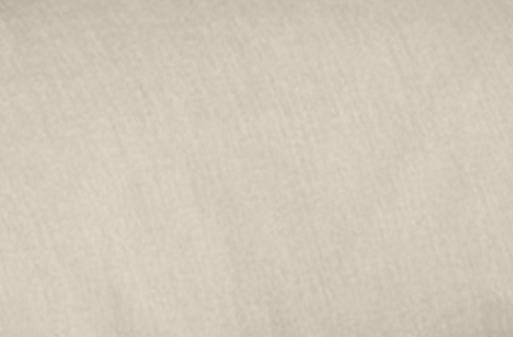 A smooth, light beige fabric texture background.