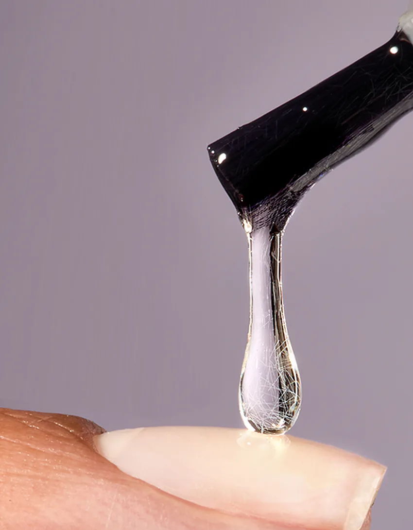 A drop of liquid falling from a tool onto a surface.