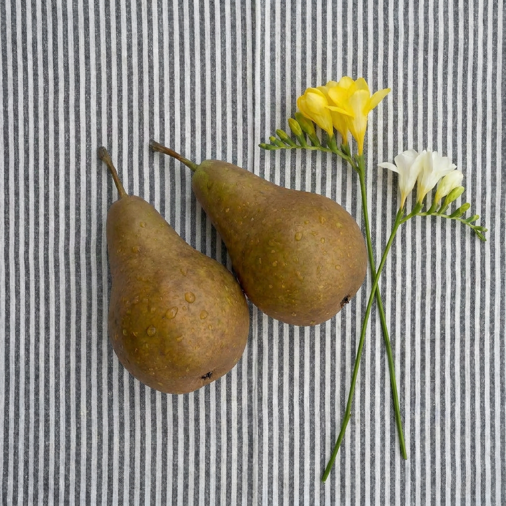Two pears and yellow and white flowers on a striped background.