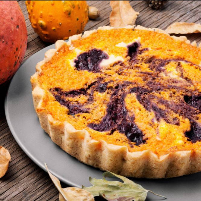 orange pumpkin pie with a berry swirl on a fall tablescape