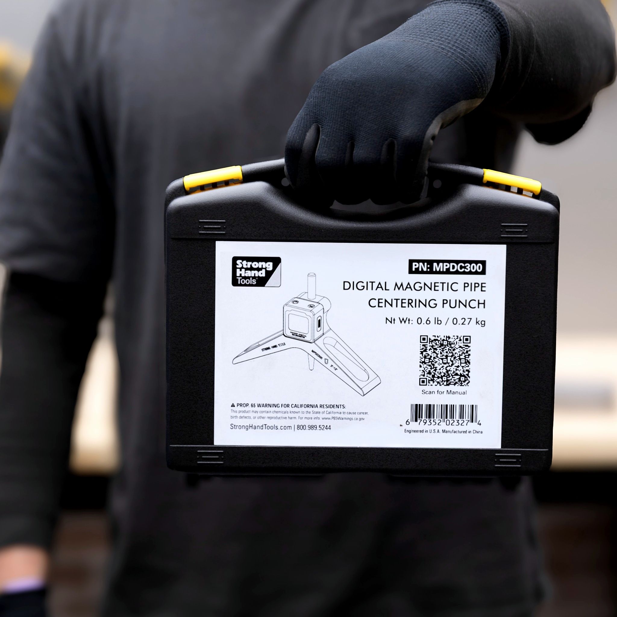 A person holding a black case labeled 