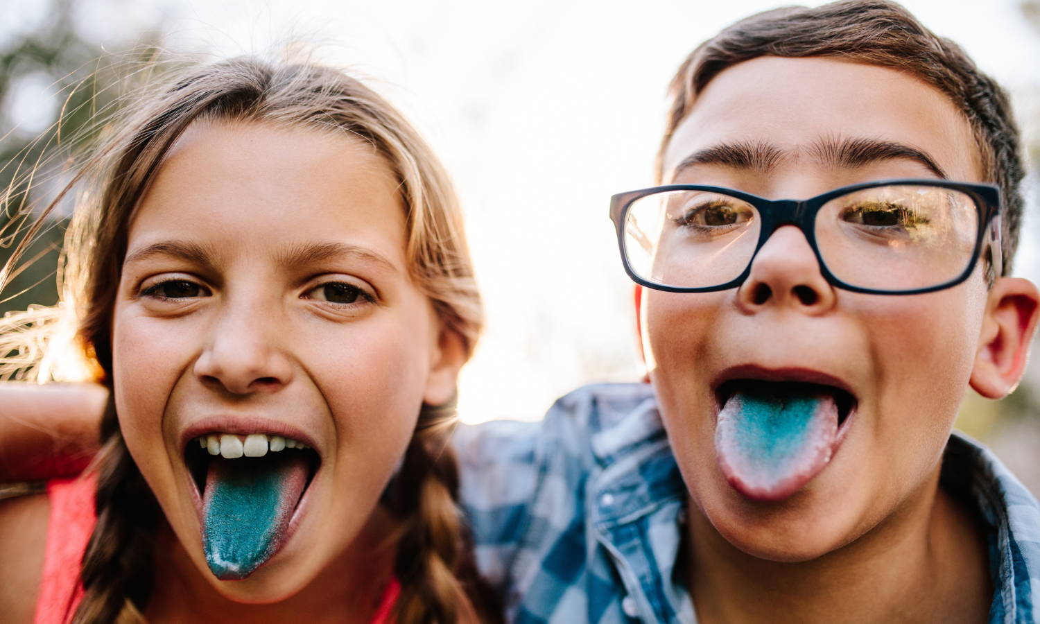 two kids poking their stained koolaid blue tongues out 