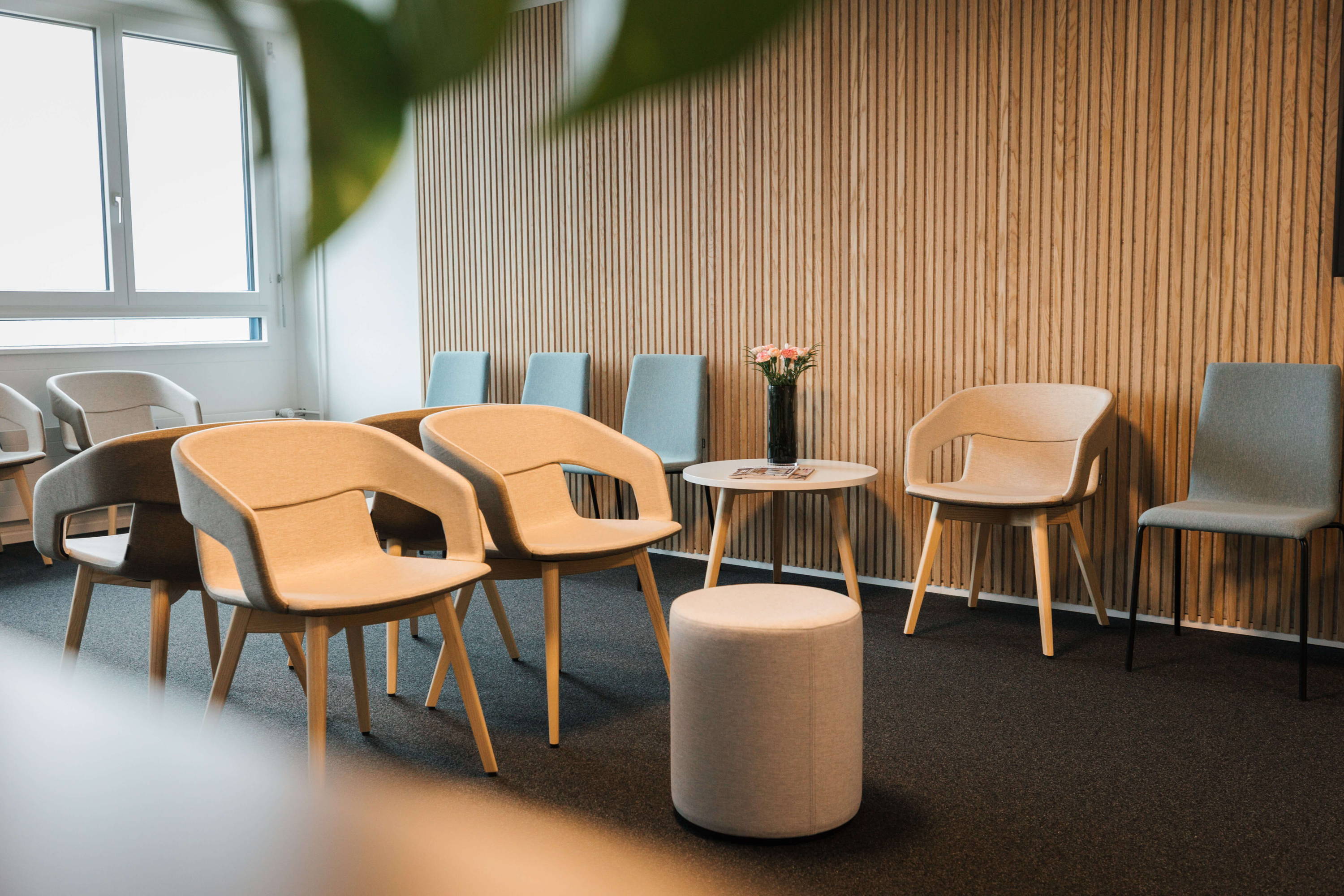 A beautiful lounge furnished with white chairs, stools, and tables by ofinto