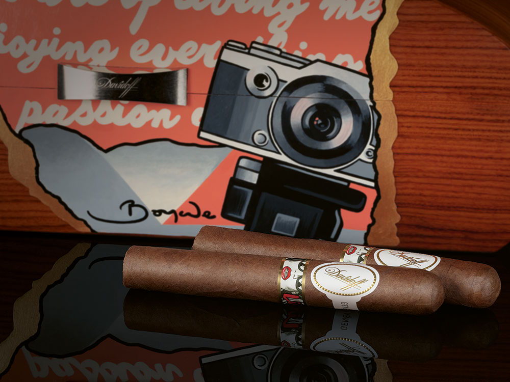 The front of the Davidoff & Boyarde Masterpiece Humidor Classically Noir with two exclusive toro cigars placed in front of it.