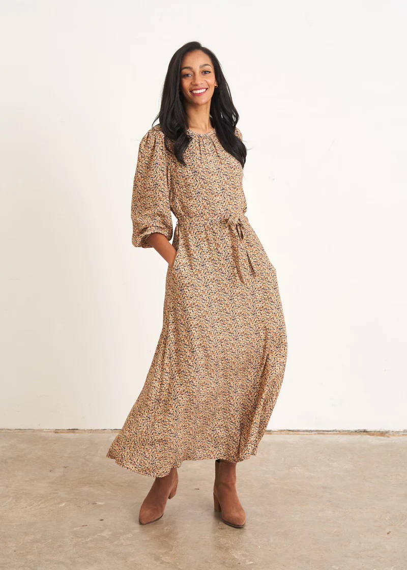 A model wearing a midaxi floral long sleeved dress with brown heeled boots