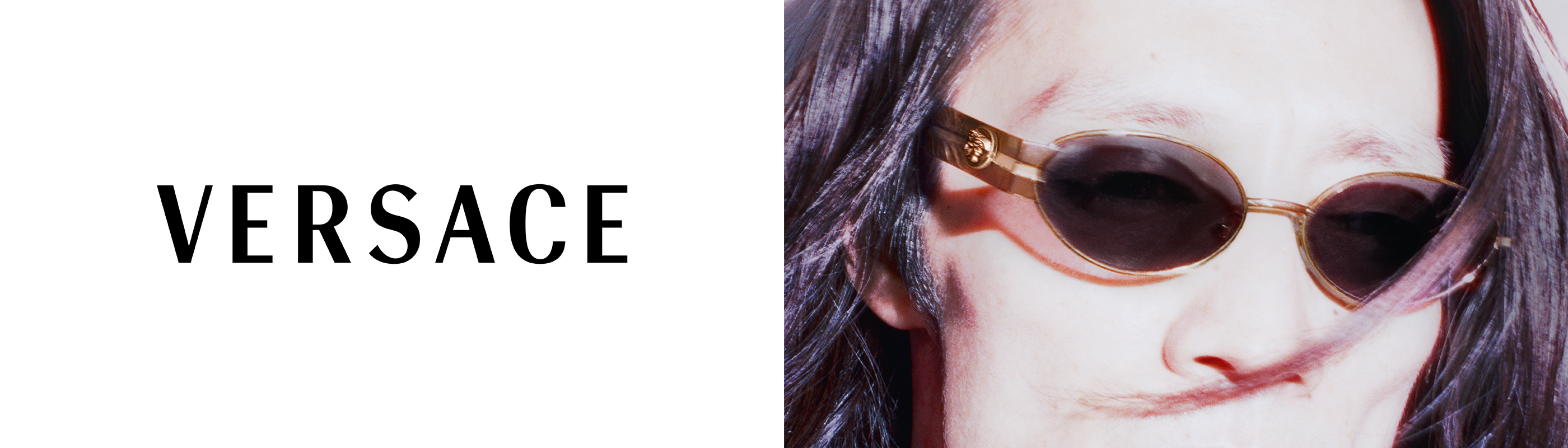 Person wearing sunglasses, featuring the Versace logo.