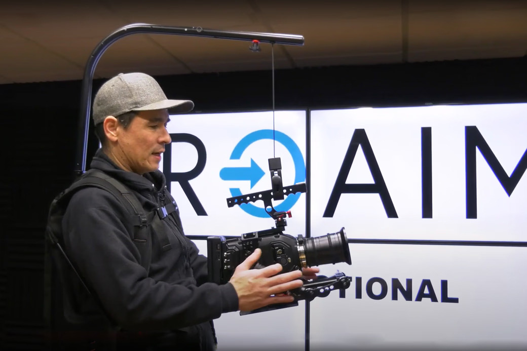 Person holding a camera in front of a sign that reads 