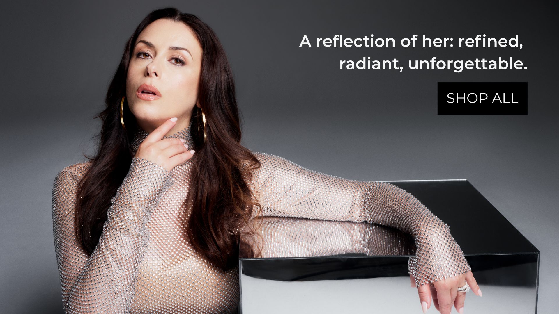 A woman poses thoughtfully beside a box, promoting elegance and style.