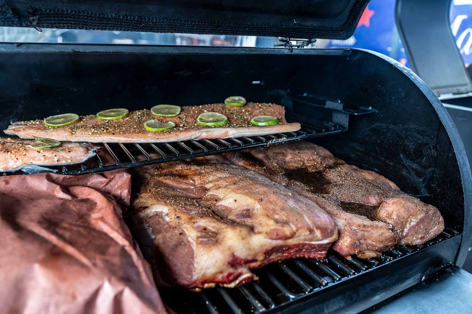 Grilled meats and vegetables on a smoker grill.