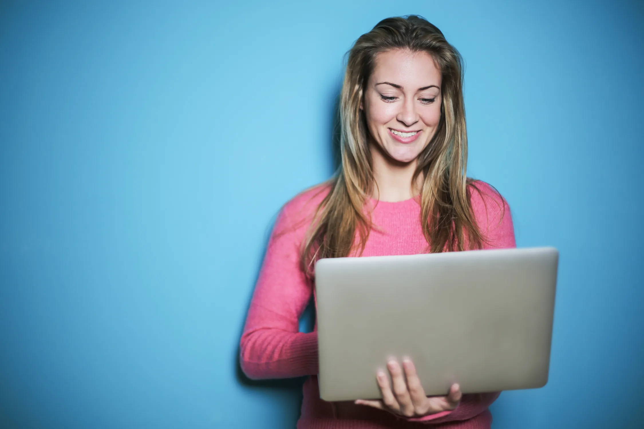 Woman In Pink Long Sleeve Top Holding Silver Laptop