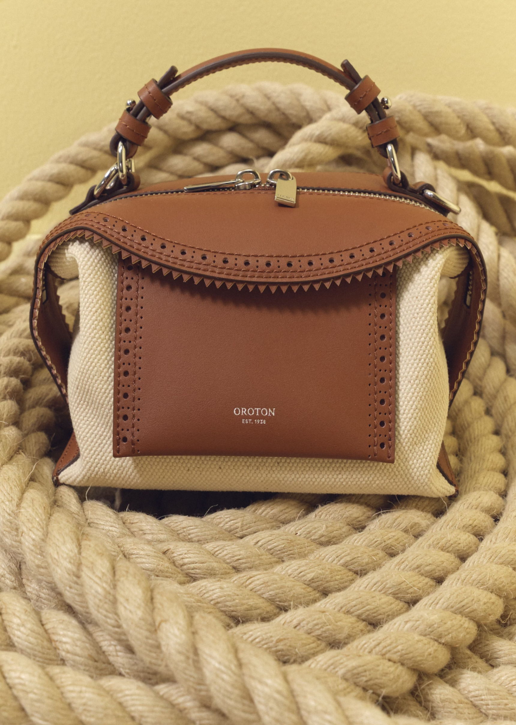 A stylish handbag resting on a coiled rope background.