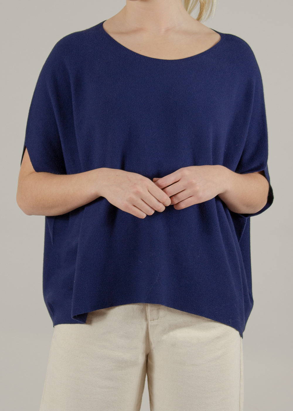 A model wearing a short sleeved dark blue sweater