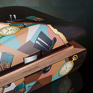 The Davidoff & Boyarde Masterpiece Humidor Geometrically Speaking with two cigars placed crosswise in front of it. 