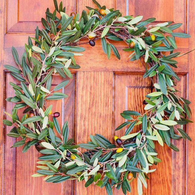 An artificial olive wreath from Nearly Natural decorated on an entrance door