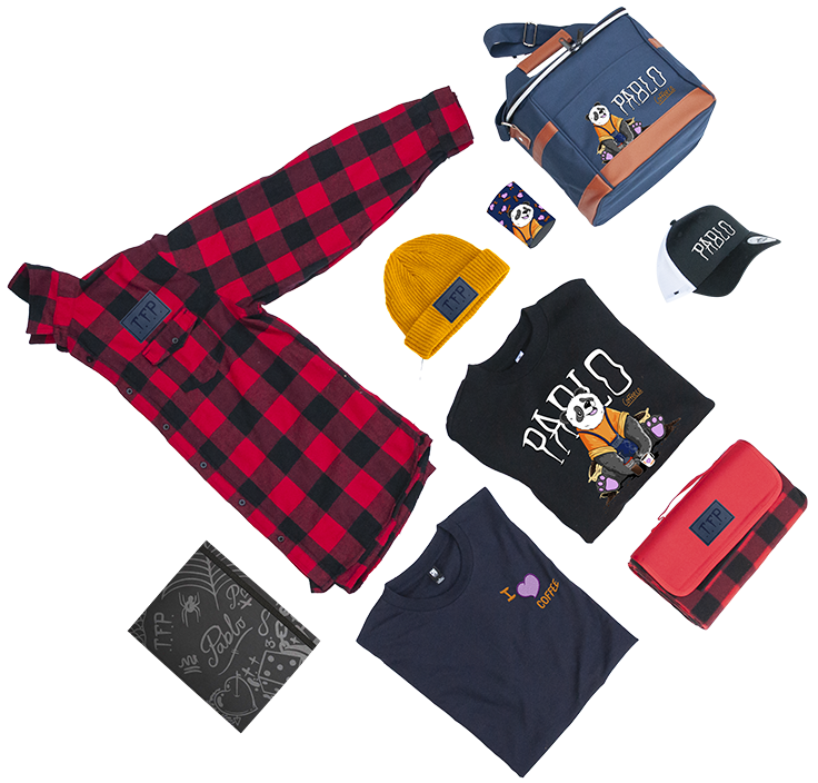 A flat lay of pablo coffee co branded merch items including red and black flannel shirt, yellow beanie, black Pablo t-shirts, denim blue cooler bag, and accessories