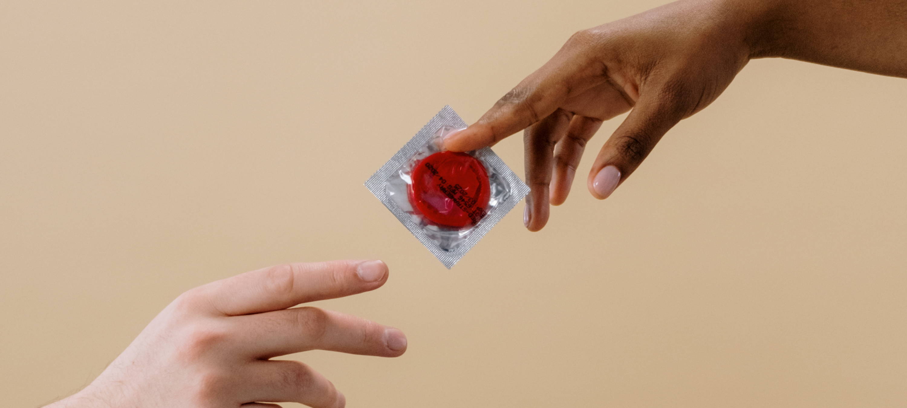 Person übergibt Kondom an andere Person