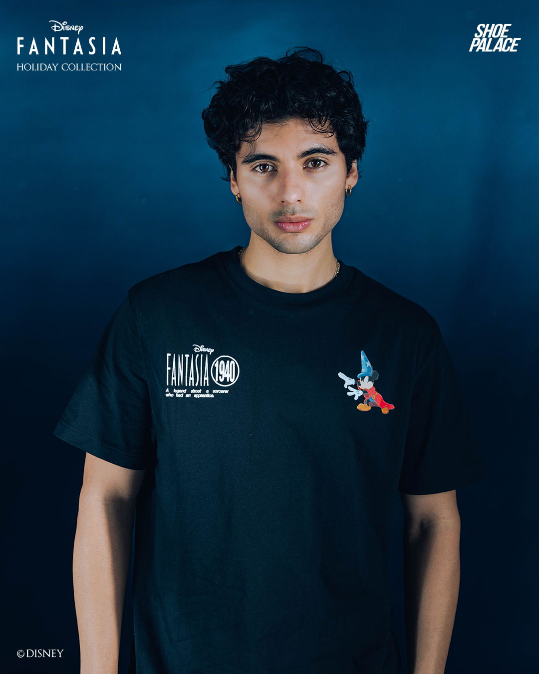 Young man in a black t-shirt against a blue background.