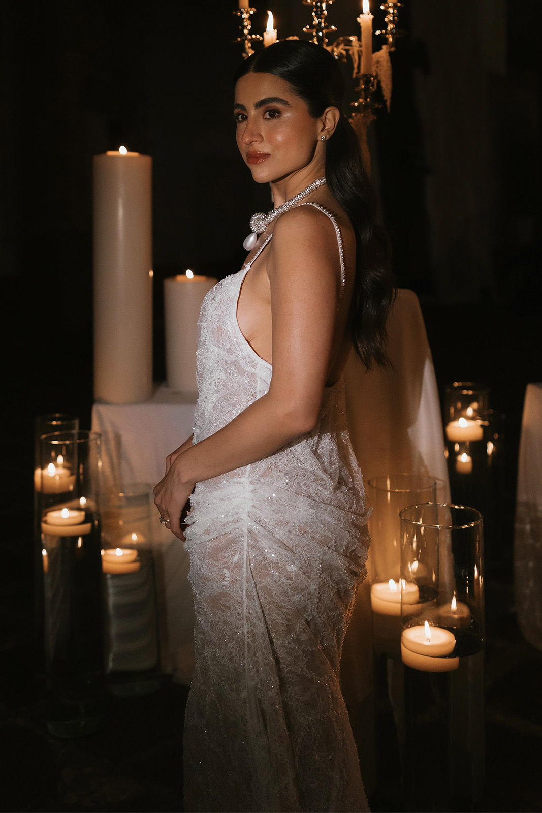 Bride in front of a display of candles in her second look, the Babette Gown