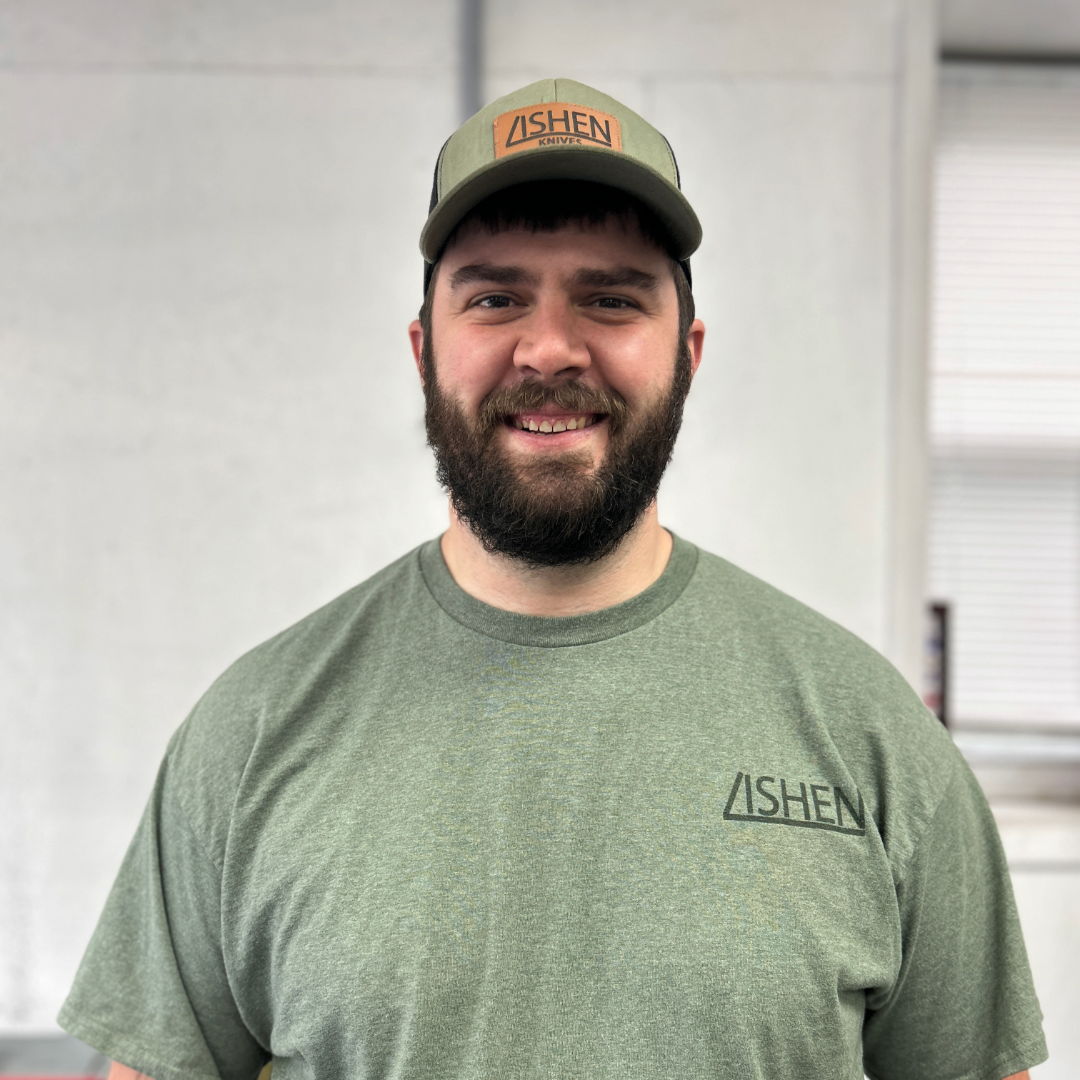 Smiling man with a beard, wearing a green shirt and cap.