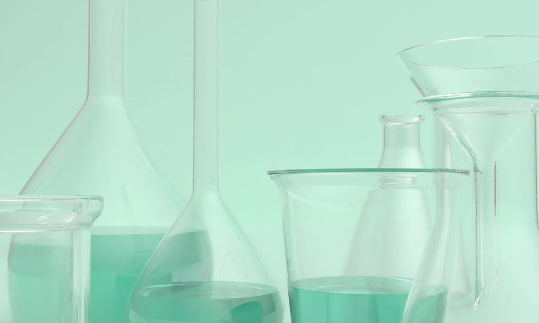 Laboratory glassware contains a light-green liquid.
