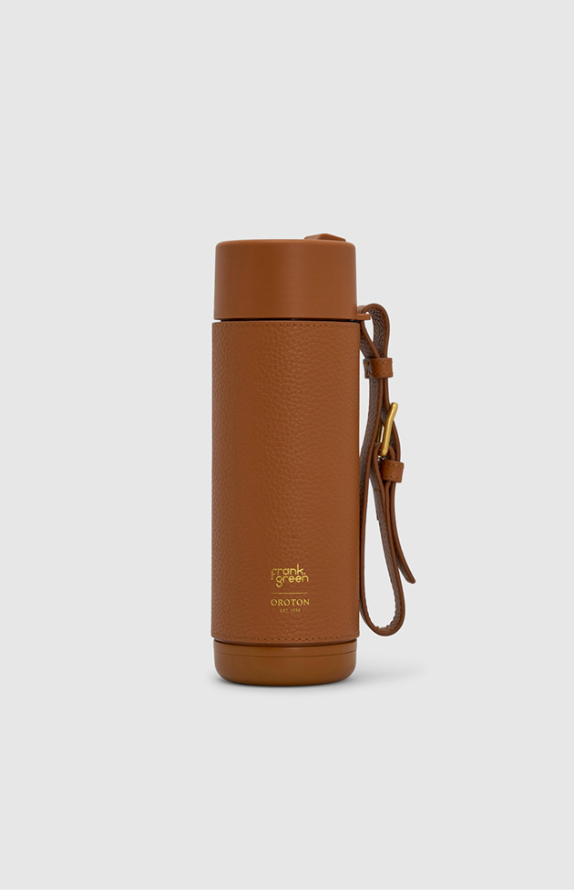 Brown insulated travel mug with a strap and gold branding.