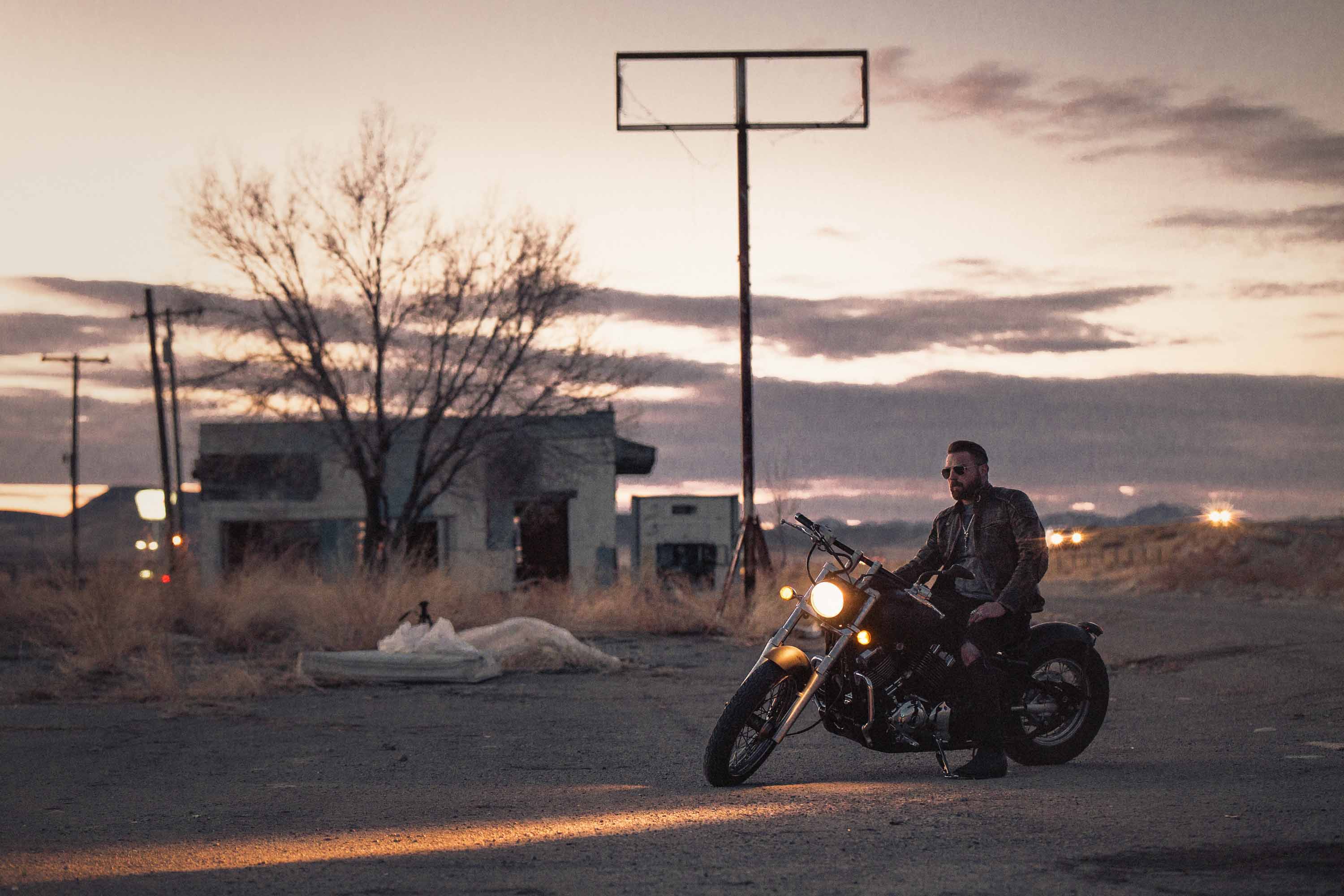 A man on a motorcycle at dusk