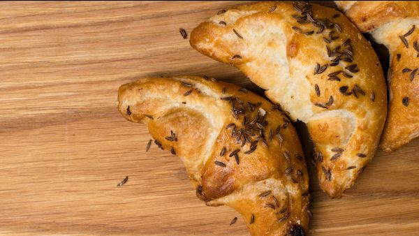 whole cumin seeds sprinkled on savory bread shaped croissants