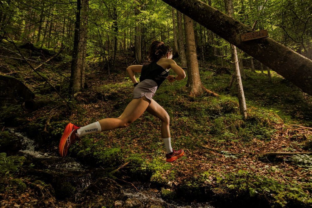 Eine Frau beim Trailrunning durch den Wald.