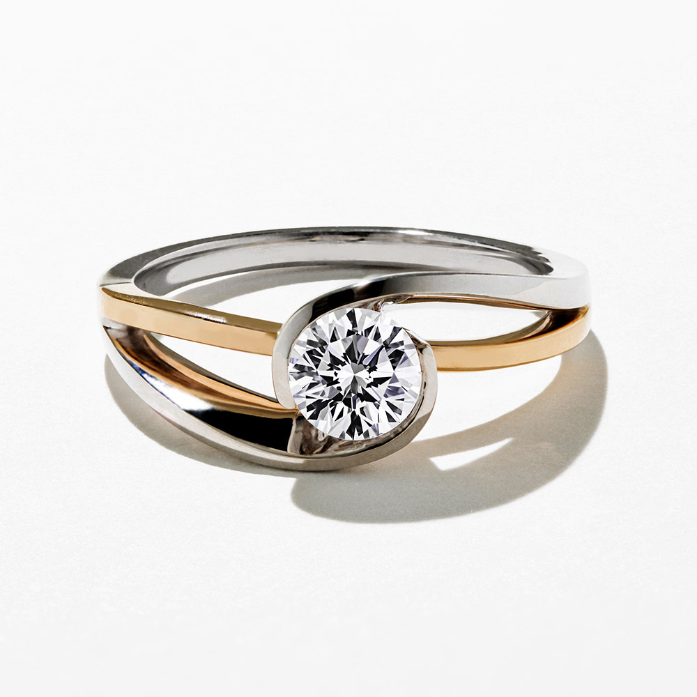 modern tension style bezel set two tone engagement ring with round cut diamond
