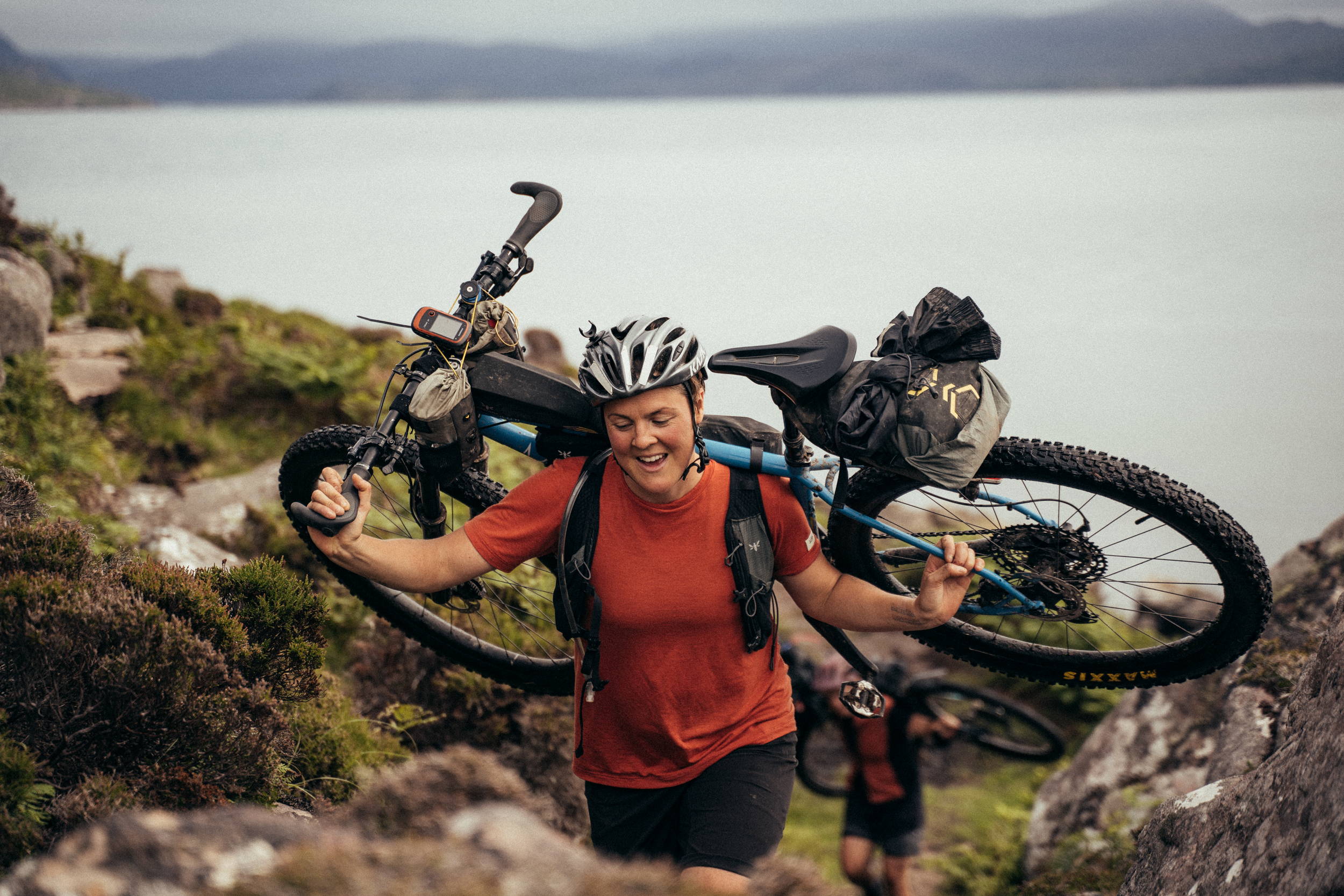 Phillipa Battye hiking her bike up a mountain