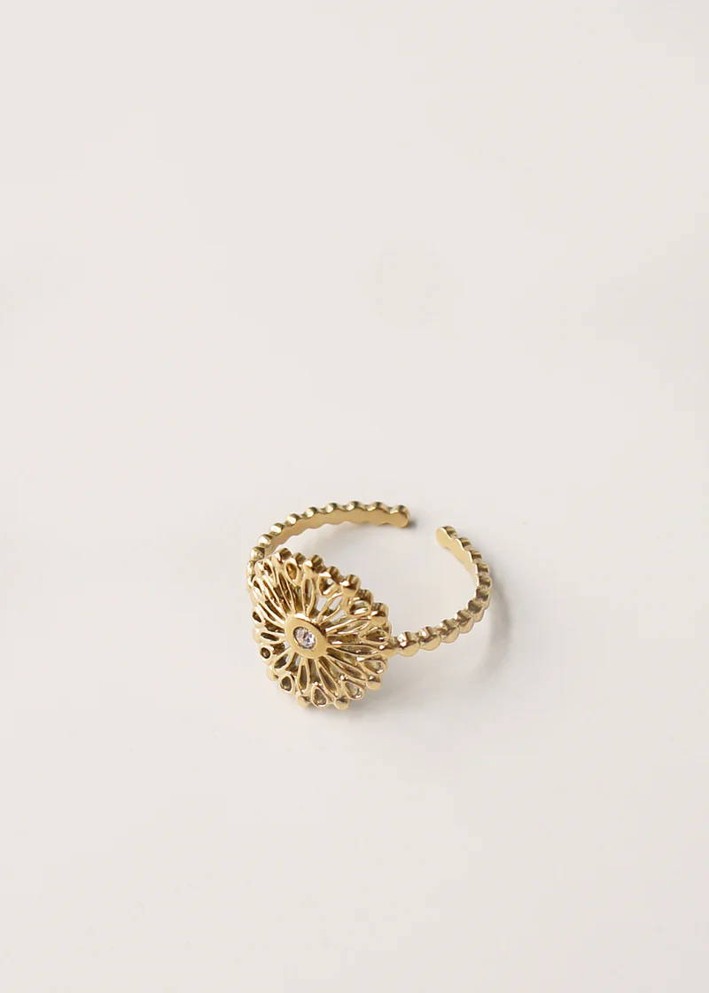 A delicately detailed gold ring with a small diamante centre piece