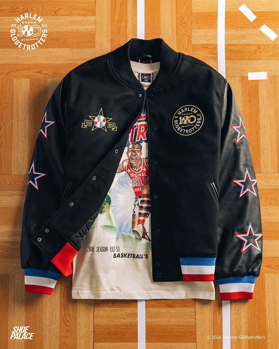 Black varsity jacket with colorful embroidery laid over a graphic t-shirt.