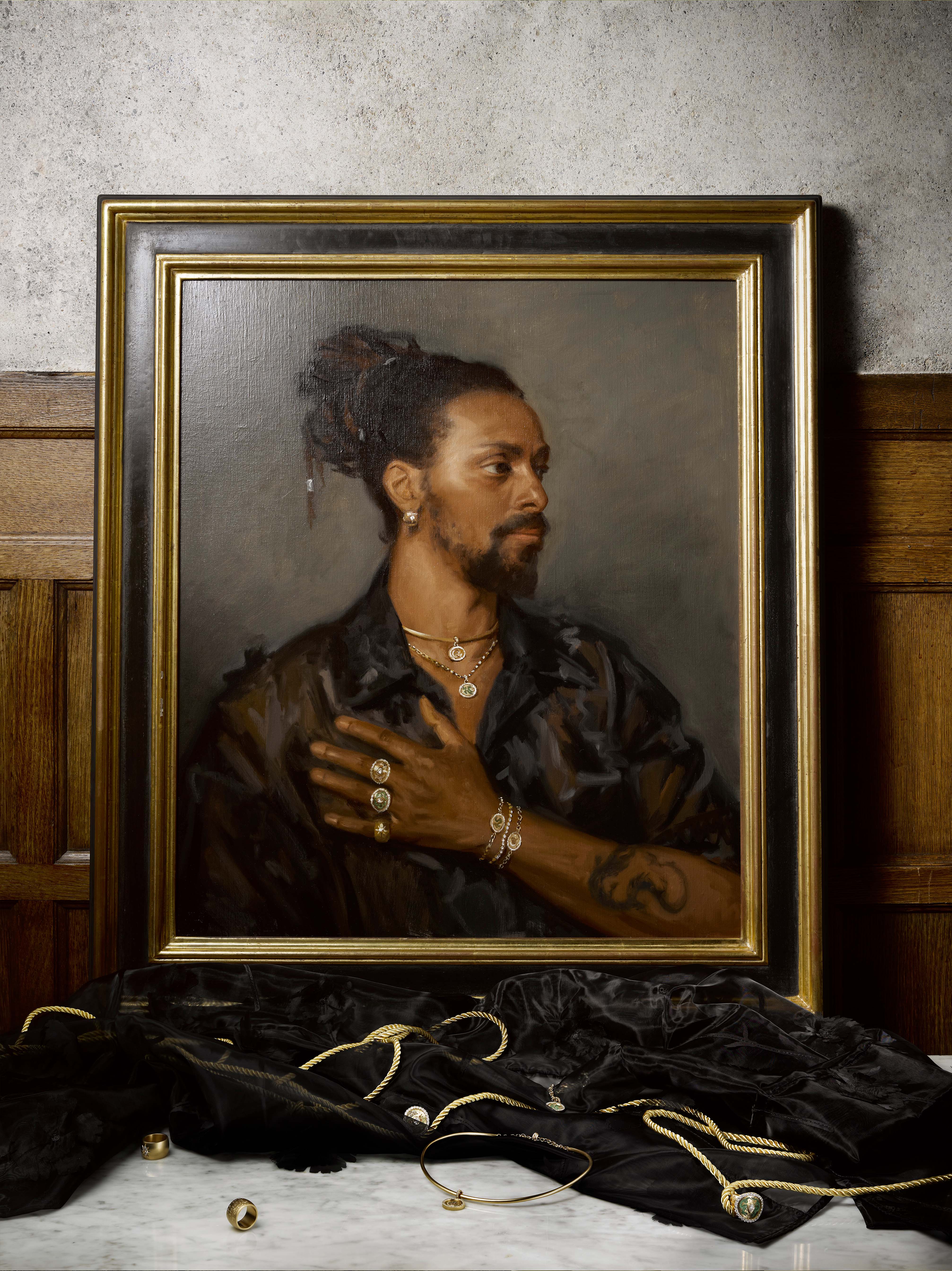 Portrait of a man with jewelry, framed against a textured background.