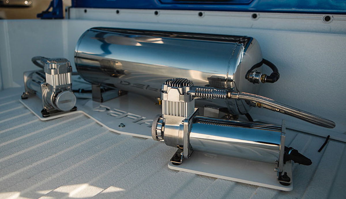 Chrome air tank and dual compressors mounted in a white truck bed