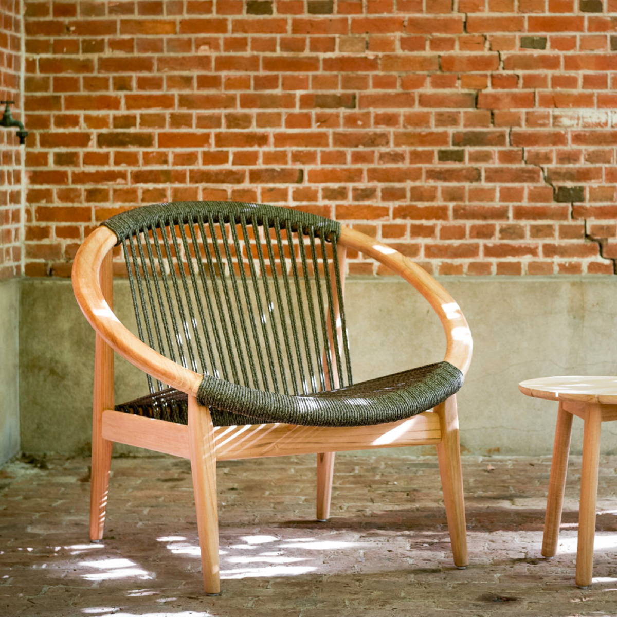 A striking chair featuring round teak frame and forest green woven seat.