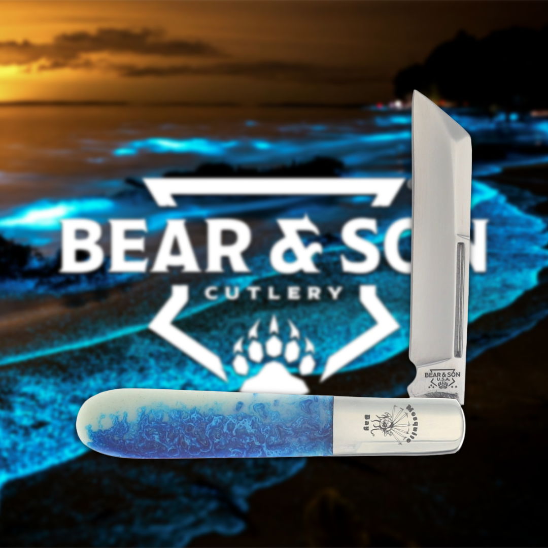 A folding knife with a blue handle against a beach background.