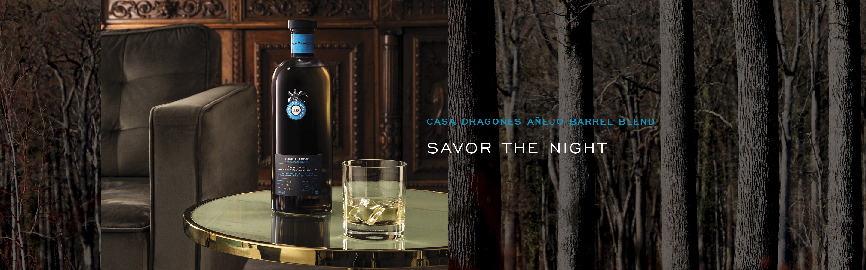 A bottle of liquor on a table next to a glass.