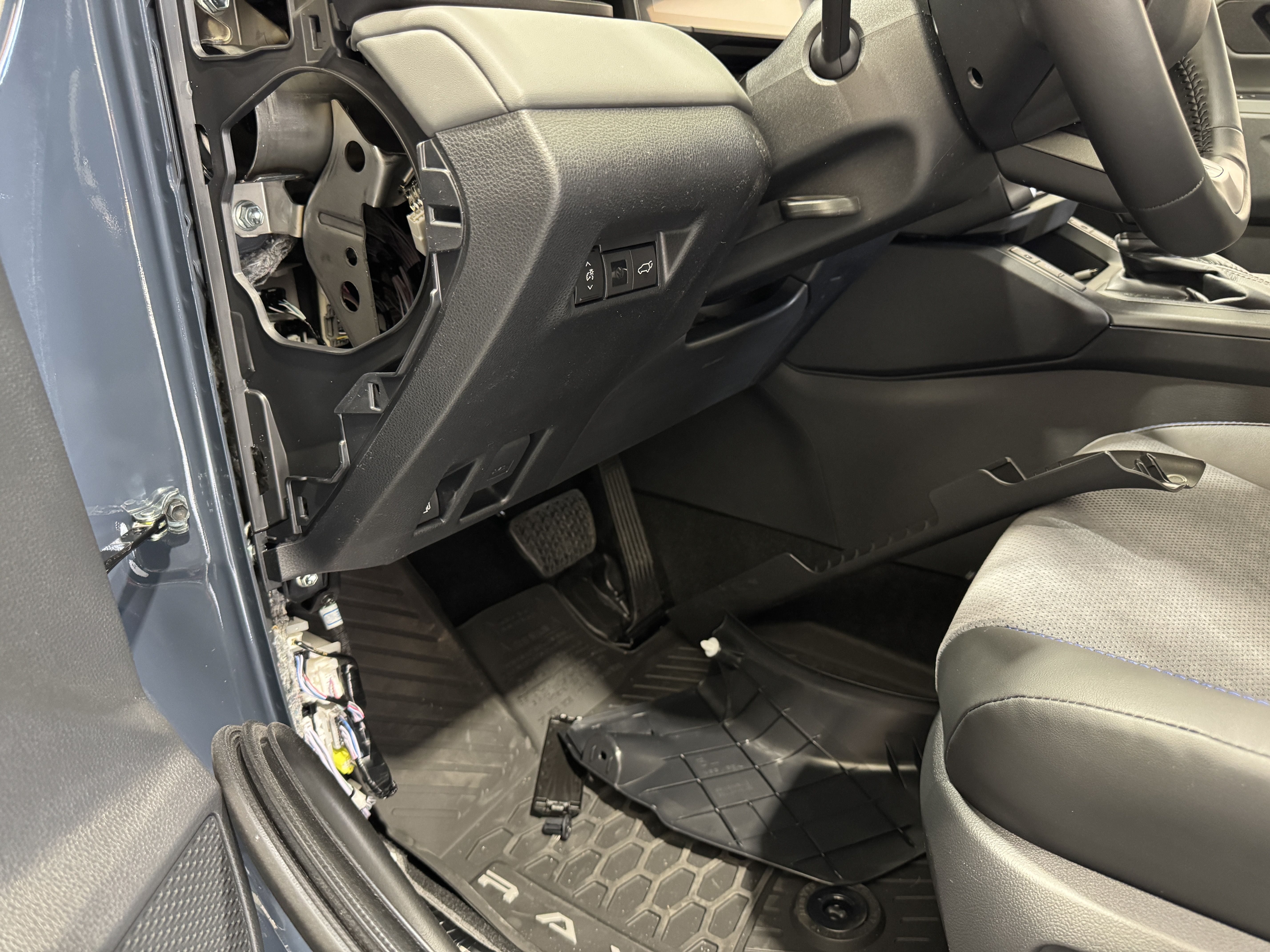 Interior view of a car showing the dashboard and driver's seat area.