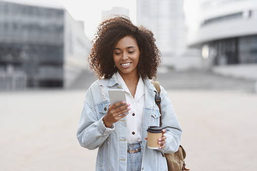 Happy, stylish woman checking phone