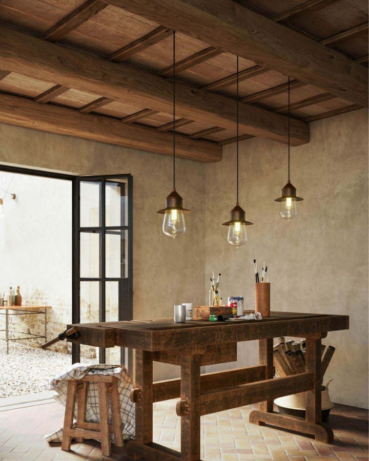Three Antique Teardrop Pendant Lights hanging above a table in a country artist room