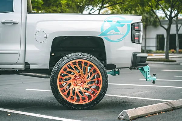 Rear side profile Nick's Silverado with XF Off-Road decal and teal train horns under bed photo 2