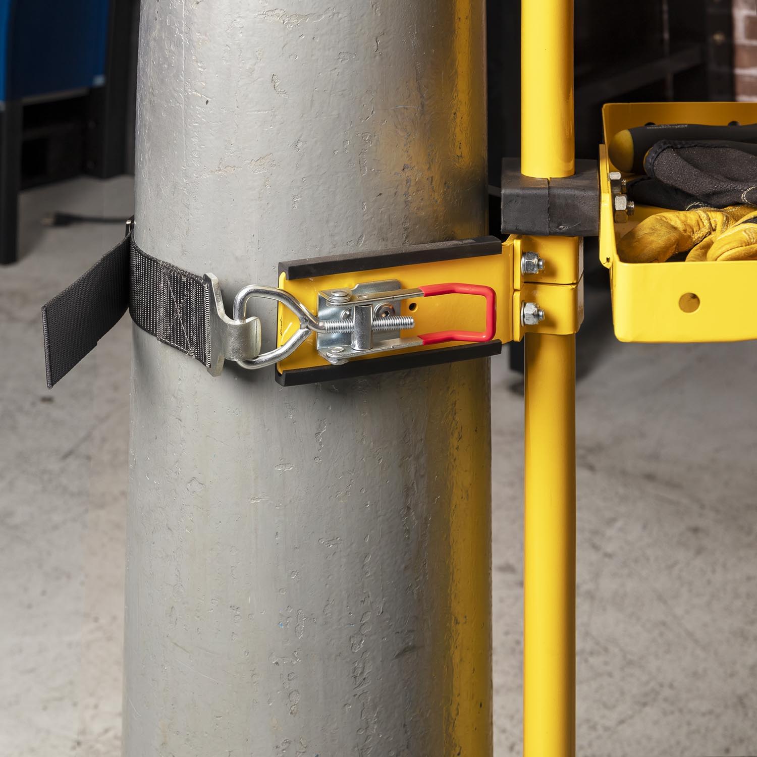 Metal pole secured with a yellow clamp and safety strap.