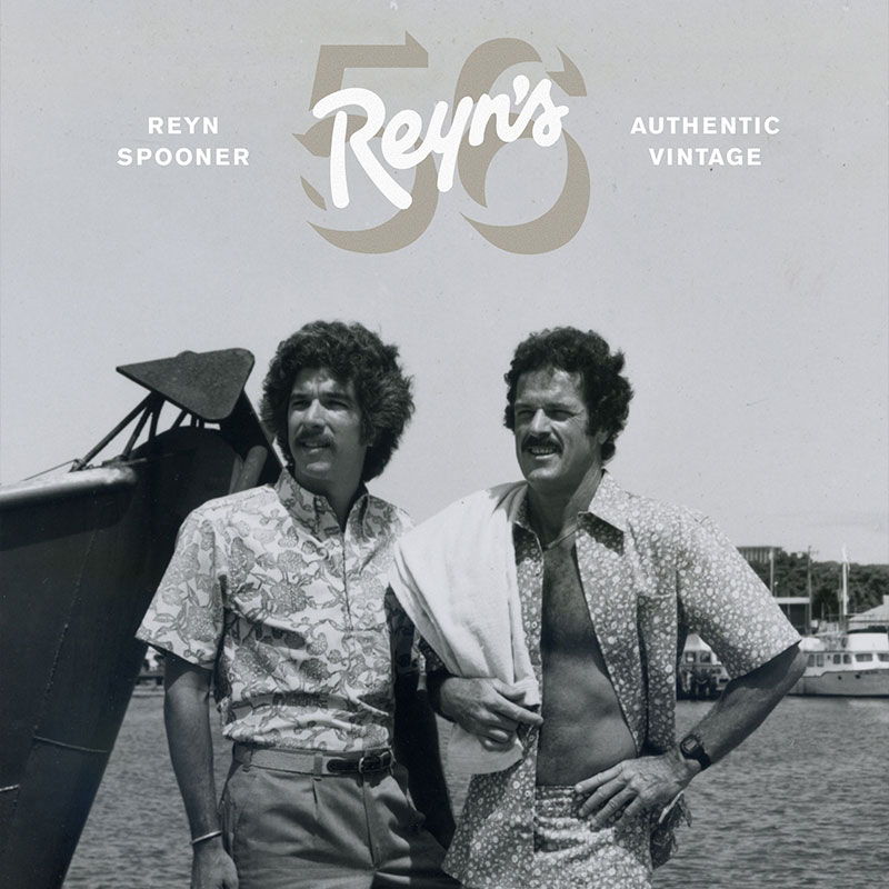 Two men standing near an aircraft, vintage style.