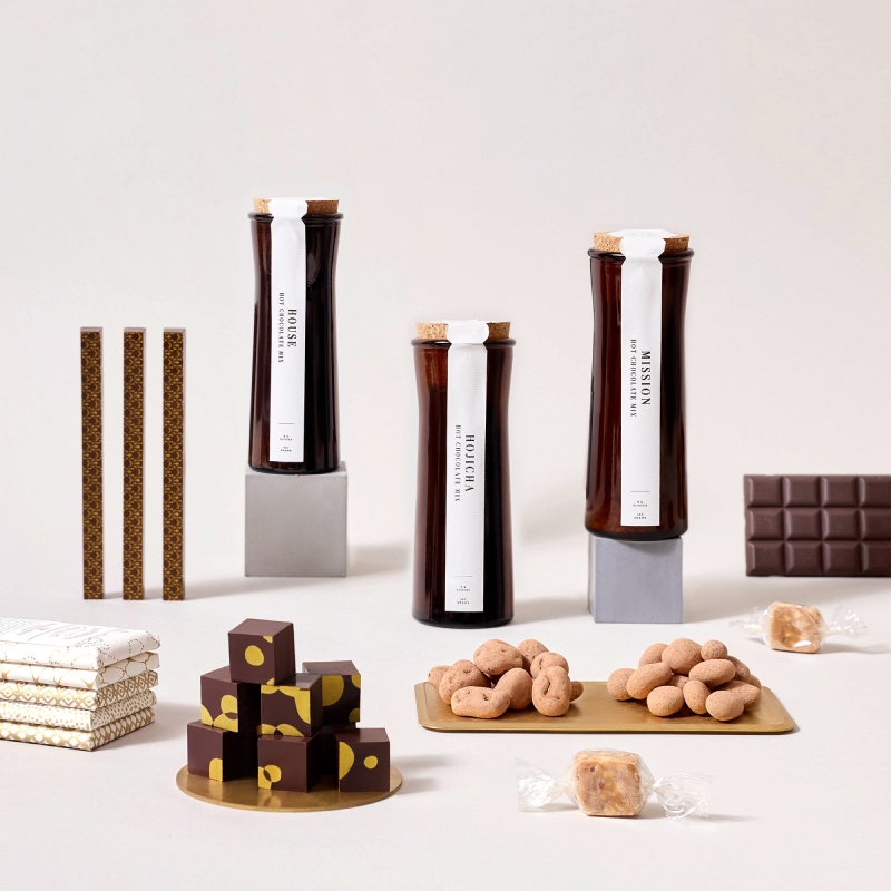 Bottles, chocolates, and snacks arranged aesthetically on a light background.