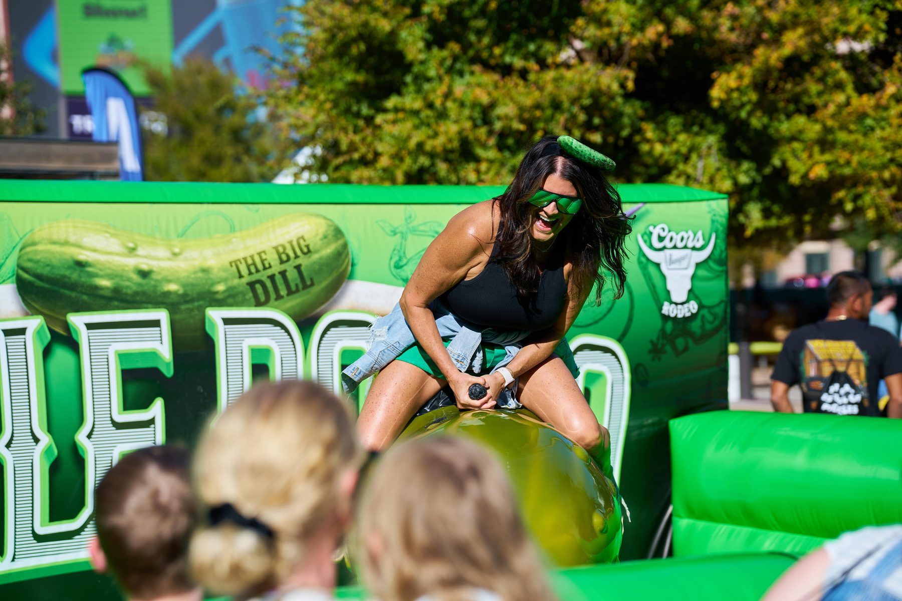 Guest riding the inflatable Pickle Rodeo bull at The Big Dill Coors-sponsored activation Arlington Texas 2025.