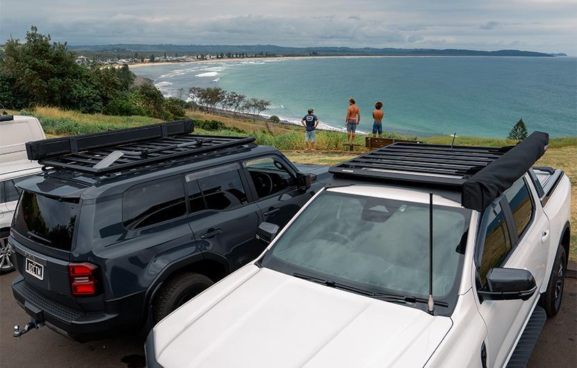 Two vehicles with Yakima Roof Rack Platforms in front of beautiful beach scene