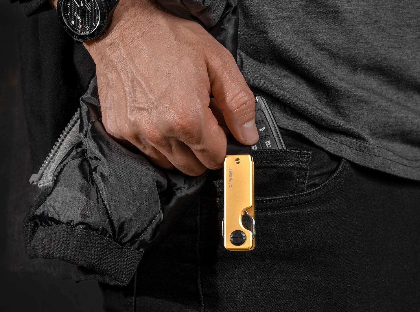 man pulling out a 24K Gold keycase and car keys on front pocket